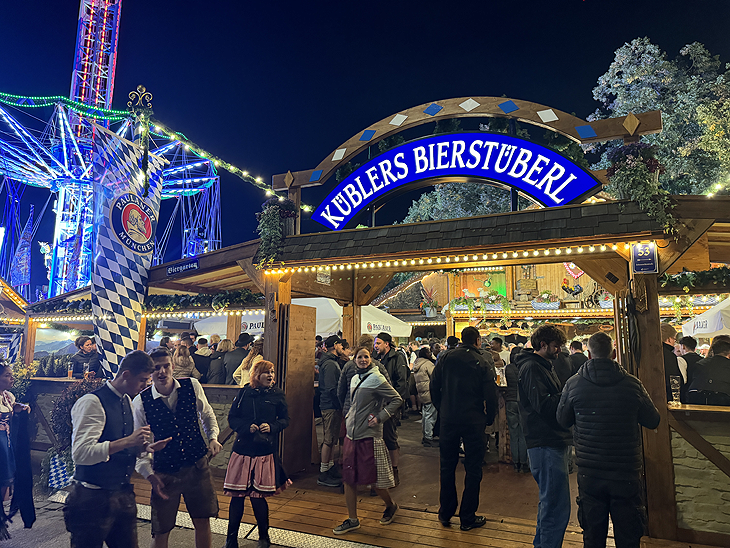 Kübler's Bierstüberl steht beim Oktoberfest 2025 am Haupteingang der Wirtsbudenstraße vis à vis dem Marstall 